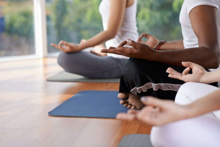 Cropped image of people meditating in lotus position