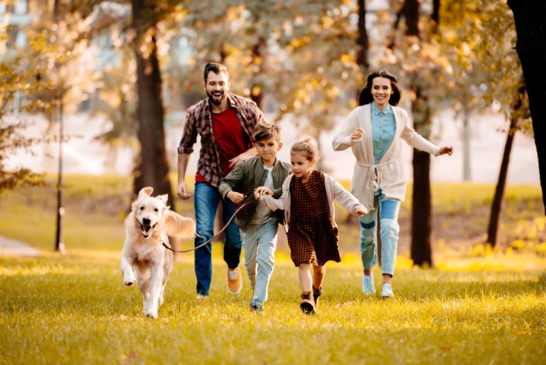 Happy family running in park with dog