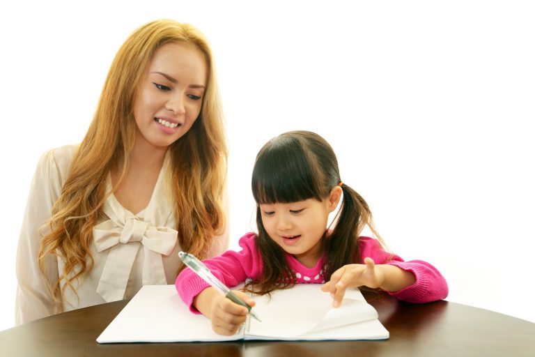 a teacher guiding her student while writing