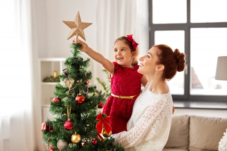 a mom and daughter decorating the Christmas tree